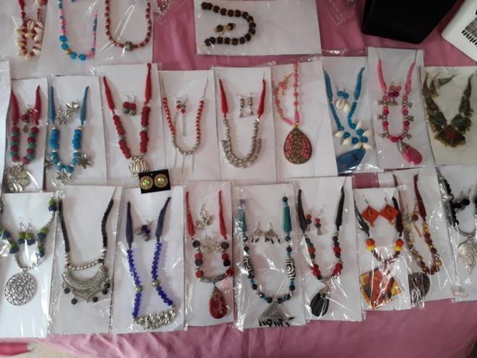 Handmade necklaces and earrings made by DAND trainees on display.