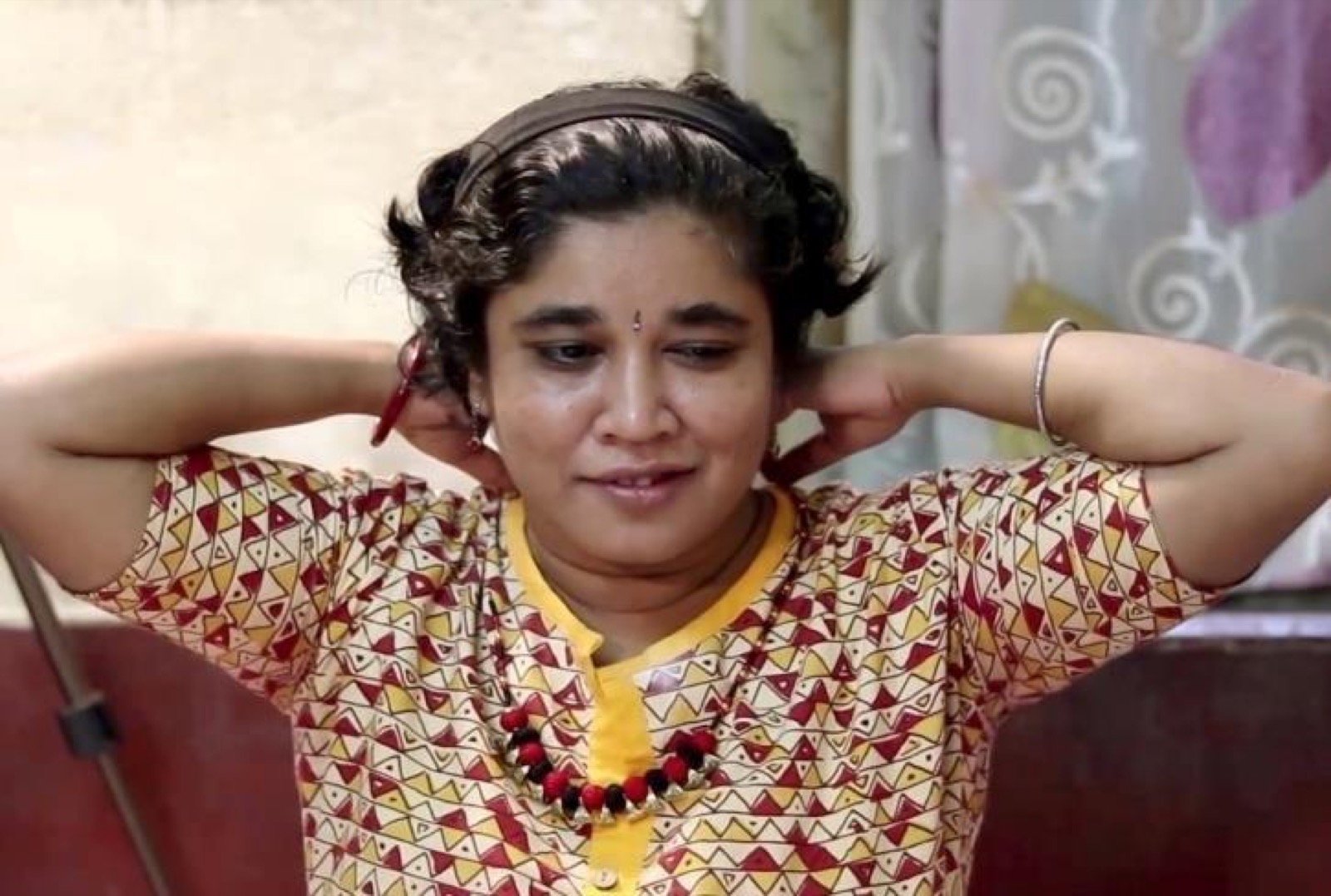 A young woman tries on a pair of handmade earrings.